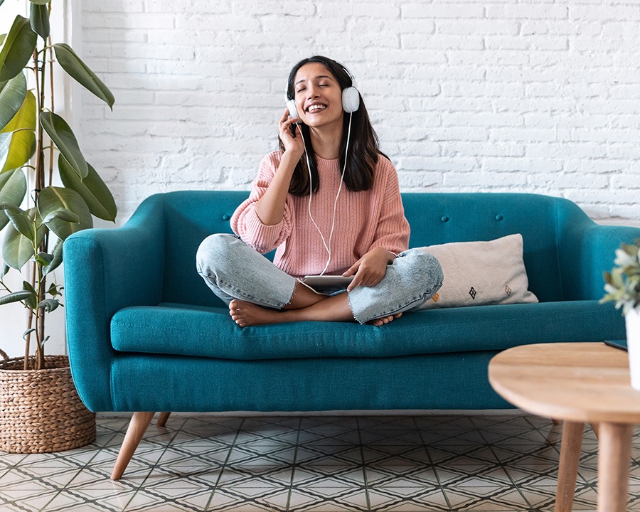 Woman with headphones on a couch doing the safe and sound protocol therapy in Texas