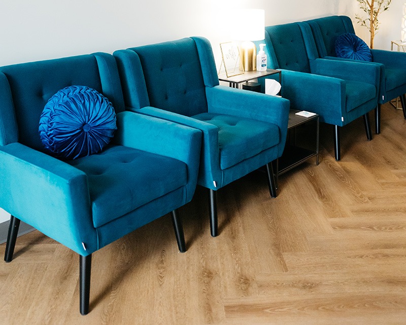 therapy waiting room with several blue cushioned chairs and table along the wall in Texas